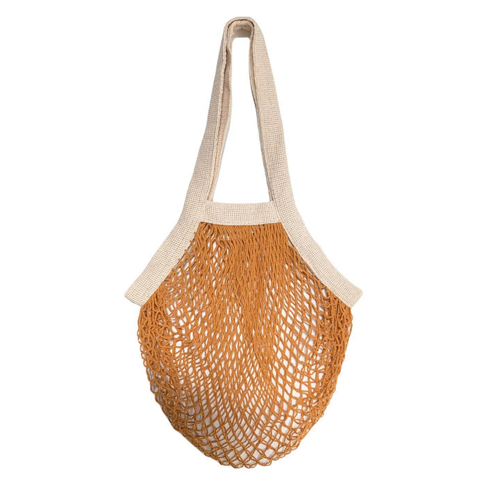 A goldenrod cotton net bag with cream-colored woven handles and trim, shown against a plain white background.