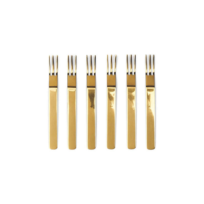 Set of six gold appetizer forks on a white background.