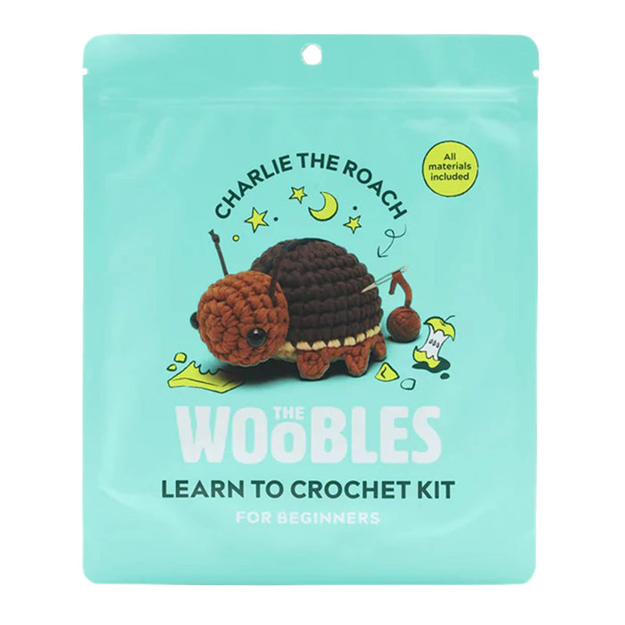 Front of teal pouch packaging for The Woobles Charlie the Roach beginner crochet kit, on a white background.