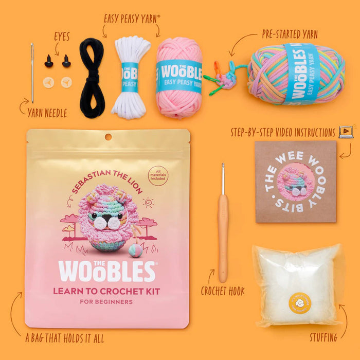 Woobles crochet kit with yarn, hook, and packaging on an orange background.