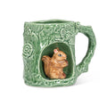 A green ceramic mug designed to look like a tree trunk, featuring a 3D brown squirrel figurine sitting inside a hollowed-out section of the mug, on a white background.