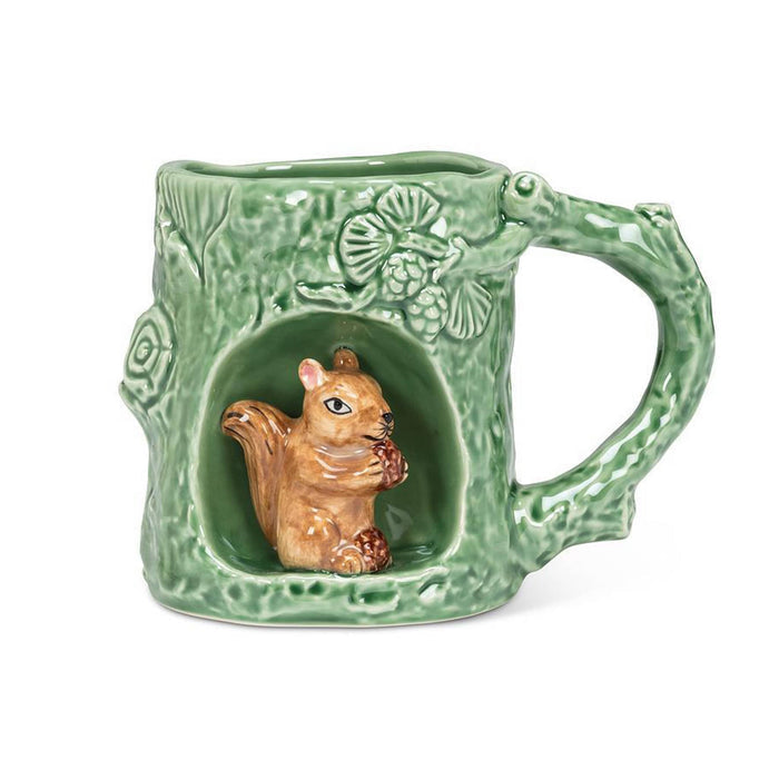 A green ceramic mug designed to look like a tree trunk, featuring a carved opening that houses a small 3D brown squirrel holding an acorn.