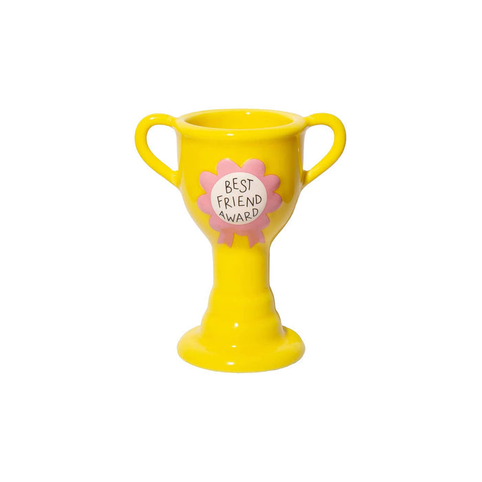 A bright yellow ceramic trophy-shaped vase with two handles and a pink ribbon rosette on the front that reads 'BEST FRIEND AWARD' on a white background.