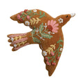 A mustard yellow velvet bird-shaped decorative pillow with intricate floral and leaf embroidery in pink, green, and gold, featuring a white beak and embroidered white beads.
