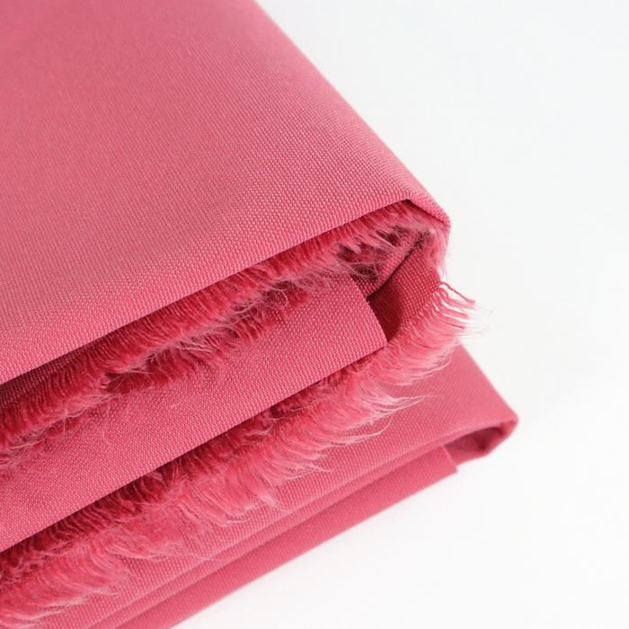 This ReNew Solid is in a soft shade of pink with red undertones. This photo is of the fabric folded.