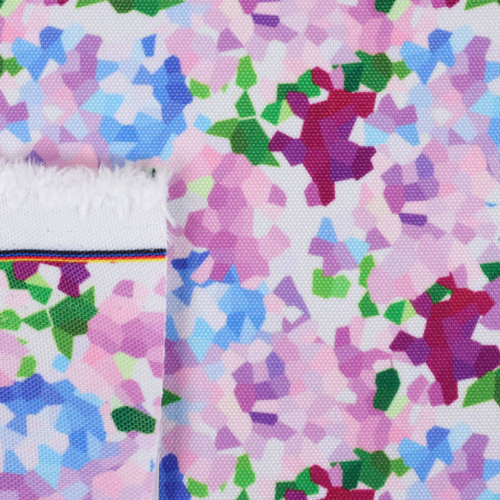 This printed WPC shows geometric shapes to resemble bunches of flowers. The colors are in an array of pinks, blues, and greens on a white background.