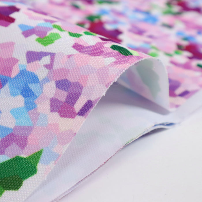 This printed WPC shows geometric shapes to resemble bunches of flowers. The colors are in an array of pinks, blues, and greens on a white background.