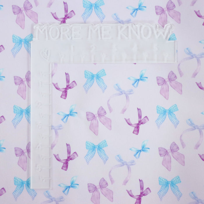 Lovely matching Ballerina Bows print on a very pale lavender/pink solid background. This photo has an L shaped ruler for scale.
