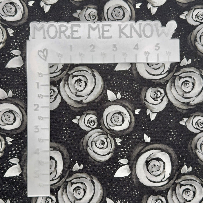 This printed WPCotton has a white rose design on a black backdrop. This photo has a white L shaped ruler for scale.
