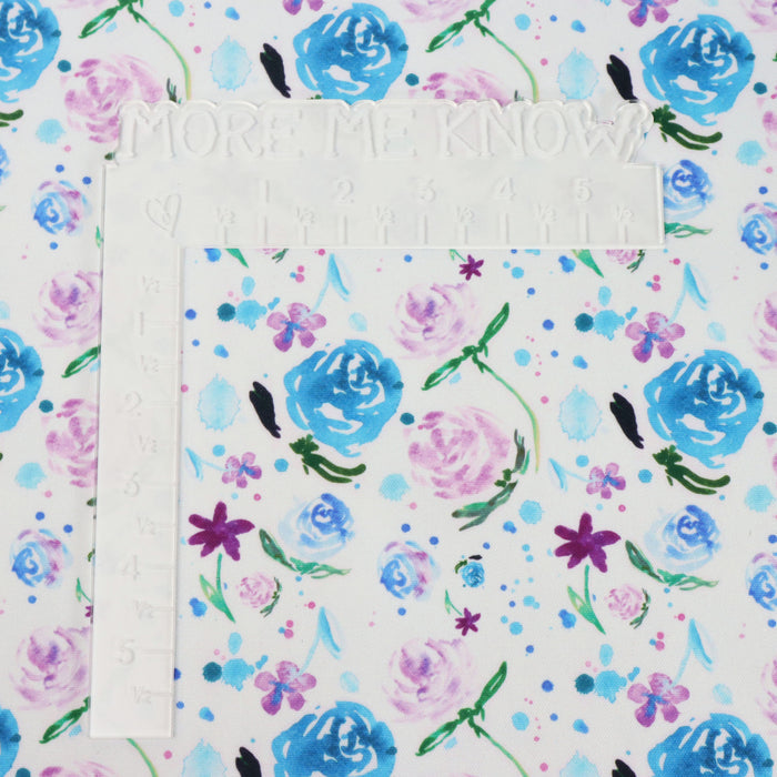 This printed WPCotton has roses and flowers in bright shades of blue, pink, and green. This photo shows a white L shaped ruler for scale.