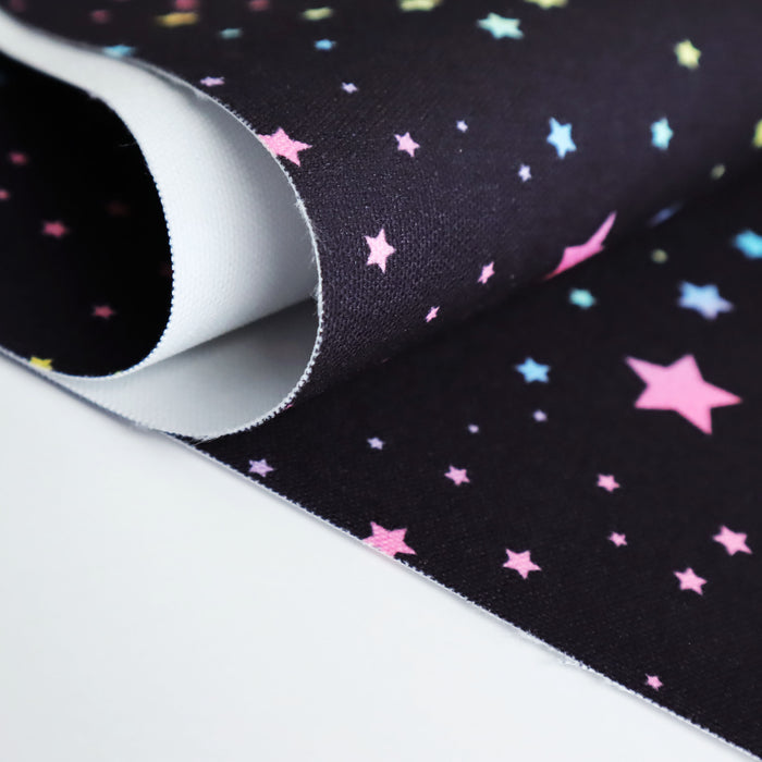 This WPCotton has pastel rainbow stars in a variety of sizes on a black background.
