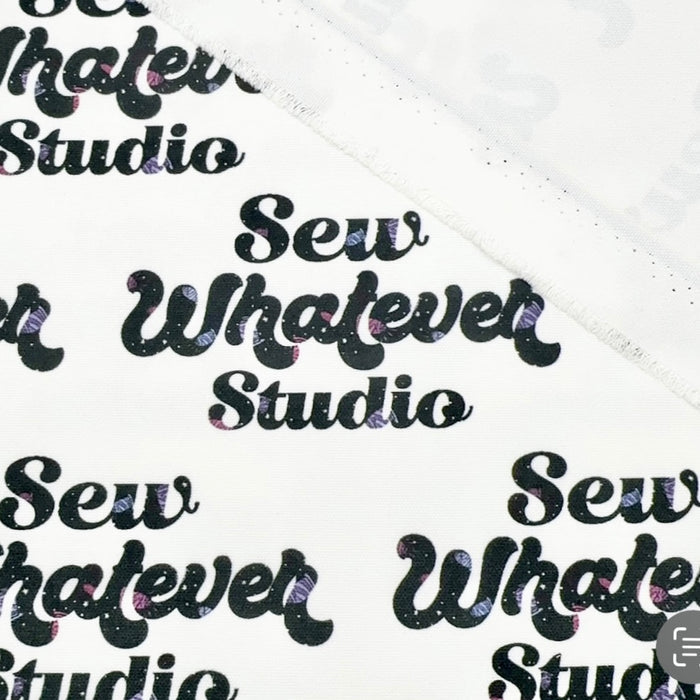 This printed WPCotton features the "Sew Whatever Studio" logo in black with multicolored spools of thread in the wording on a white background.