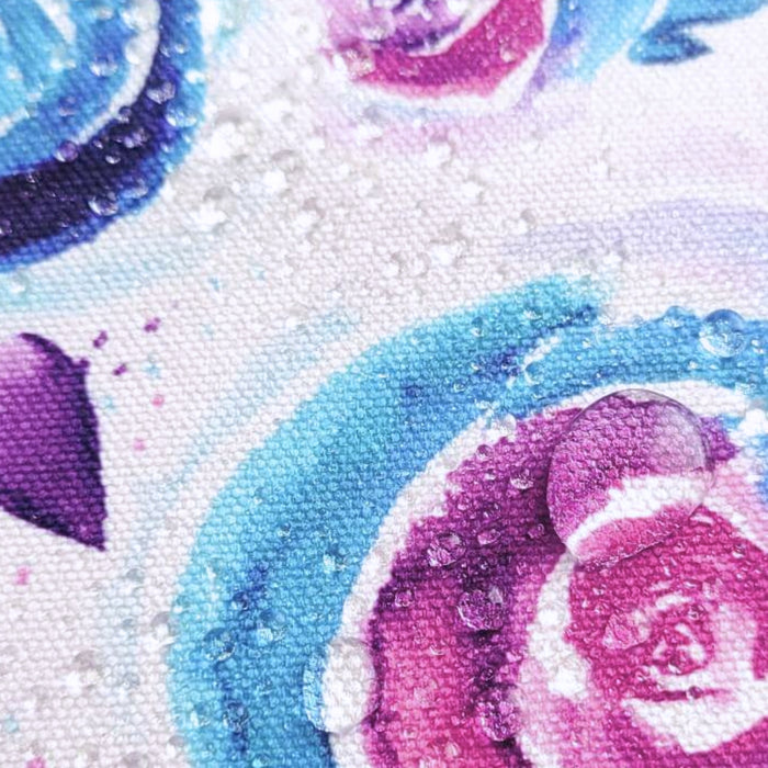 This printed WPCotton features watercolor roses in shades of blue and pink on a pale background. This photo shows water drops on the fabric.