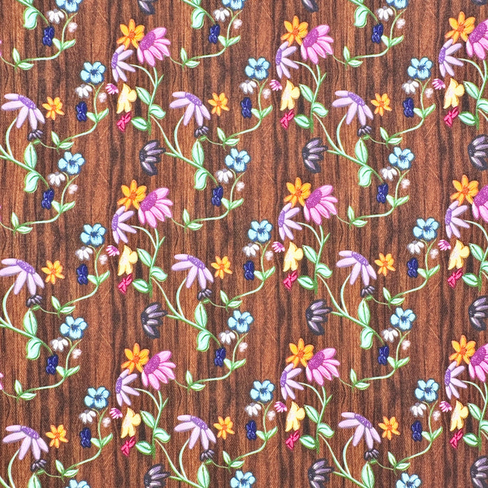 This printed WPCotton consists of different colorful flowers on a wood-esque background.